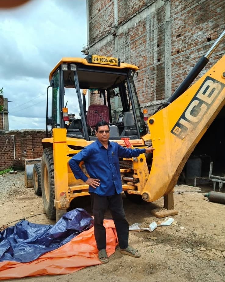 RM Earth Mover technician with JCB 3DX backhoe loader at workshop yard in Bagodar, Jharkhand